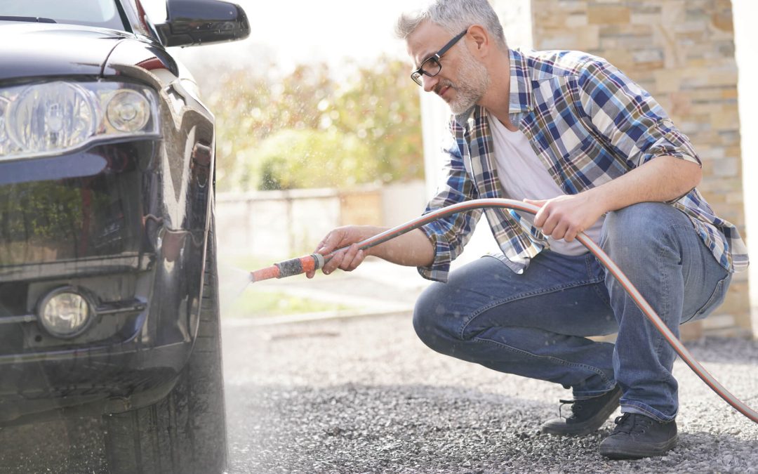 man washing his car in his driveway
